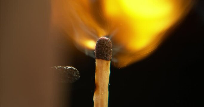 Match, fire and orange flame on black background for heat, light and lighting wood in dark studio. Ignite spark, flammable and closeup of burning matchstick for warmth, power blackout and smoking