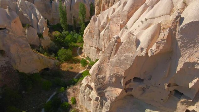 Embark on a visual journey with this mesmerizing aerial stock video capturing the essence of Cappadocia's cave dwellings near Goreme, Turkey. The bird's eye perspective unveils the unique charm of