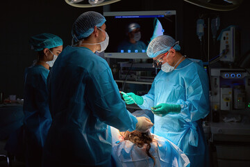 team of surgeons operate on the patient