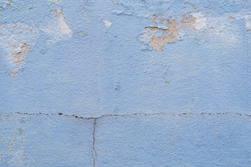 Old blue cement wall with peeling paint