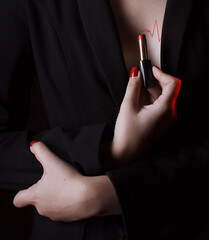 The girl in the jacket is holding red lipstick, with a pulse drawn on her chest