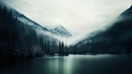 Fotobehang Mountain lake in a foggy forest with snow-capped peaks © Faith Stock