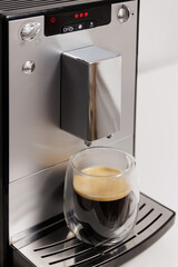 modern coffee machine with double sided glass cup of espresso