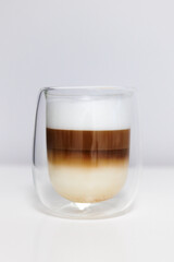 glass of fresh latte coffee with milk on white table
