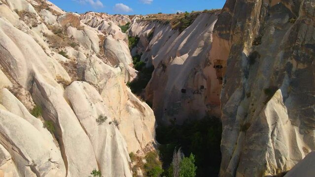 Embark on a visual journey with this mesmerizing aerial stock video capturing the essence of Cappadocia's cave dwellings near Goreme, Turkey. The bird's eye perspective unveils the unique charm of