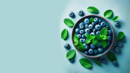 ripe blueberries with mint leaves on a light blue background