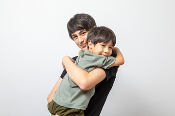 Adorable brother hugging standing on white background.