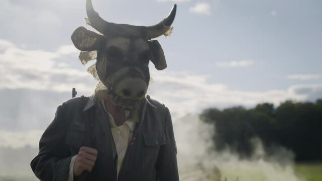 the monster walking along the road has a scary cow mask and the uniform of a German Wehrmacht soldier on his head