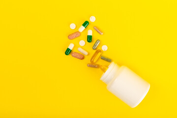 Vitamins and supplements. A variety of vitamin tablets in a jar on a textured background. A multivitamin complex for every day. Nutritional supplements.Place for text.Copy space.Vitamins for immunity