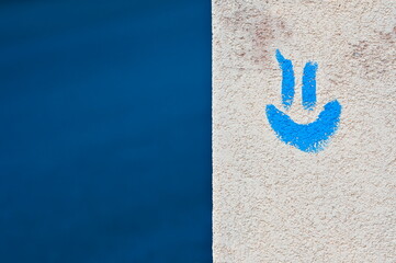 Positive emotion and smiling concept. Blue smiling emoji on the building facing and blue...