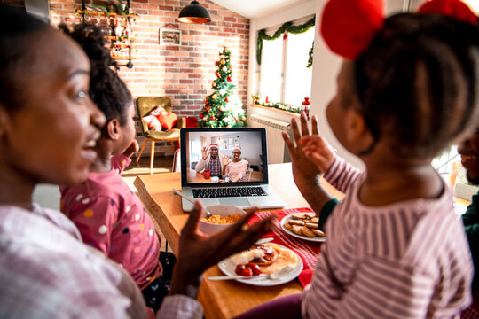 Mother showing video call with grandparents to children at home - Powered by Adobe