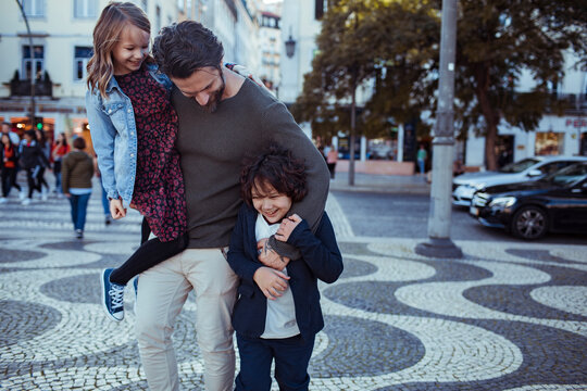 Father Enjoying a Fun Moment with His Children in a City Square
