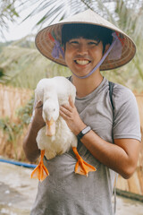 tourist holds a duck at the duck stop in Phong Nha, Vietnam.