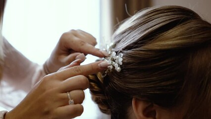 Close-up of a beautiful young bride getting her hair done and hanging her veil. morning preparations of the bride before the wedding ceremony. Hair close up