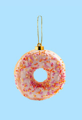 Donut Christmas tree toy on blue background. Creative collage.