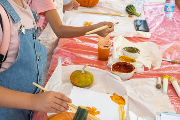 A small pumpkin that children pant. Children's creativity for Halloween, Harvest, Thanksgiving Day.