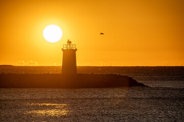 Coucher de soleil en bord de mer, sur un phare