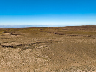 Região desértica ao lado do vilarejo de Socaire no Chile. Areia, dunas, céu azul e paisagem árida.