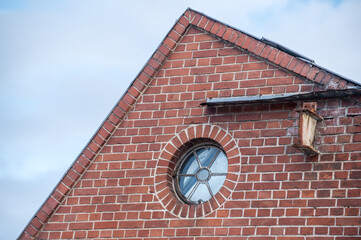Detailaufnahme altes Fabrikgeb&auml;ude mit Backsteinmauer und rundem Fenster im Industriegebiet Neckartenzlingen