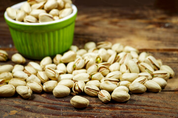 Pistachios in bowl on wooden background