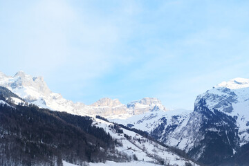 Naklejka premium beautiful winter landscape, snow-covered trees, mountainpass, snowfall in the mountains, Swiss Alps in the snow, walks in the winter white forest, tourism, winter sports