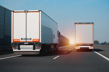 Two Modern Semi-Trailer Trucks On The Highway Driving And Overtaking Each Other. Commercial Vehicle...