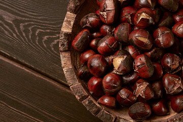 roasted chestnuts, in a wooden plate, top view, homemade, no people,