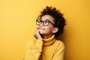 Positive contemplative hipster girl in stylish eyewear for vision correction looking away and thinking on idea for content
