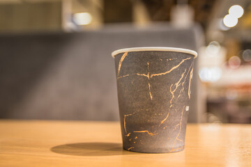 Paper coffee cup in coffee shop. Paper cup with coffee in a cafe on the table