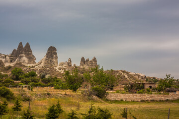 Naklejka premium Rocky landscape in Cappadocia, Turkey. Travel in Cappadocia. Unusual semi-desert mountain ranges. Amazing Rocky summer landscape with caves in Cappadocia Goreme
