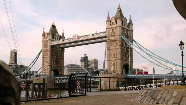 Ein roter Doppeldecker Bus &uuml;berquert die 'Tower Bridge' in London an einem sonnigen Morgen im Herbst.