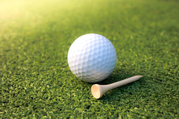 Golf balls and tees are placed on artificial grass.