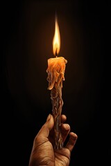 A person holding a lit candle in their hand. This image can be used to symbolize hope, peace, or spirituality. It can also be used in Halloween or horror-themed designs.