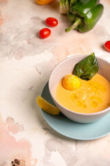 pumpkin cream soup with a slice of lemon in a plate on the table