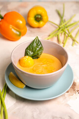 pumpkin cream soup with a slice of lemon in a plate on the table