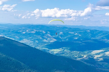 Paragliding flight with an instructor. Silhouette of paraglider against background of a beautiful...