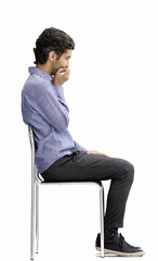 young man in full growth. isolated on a white background sitting on a chair