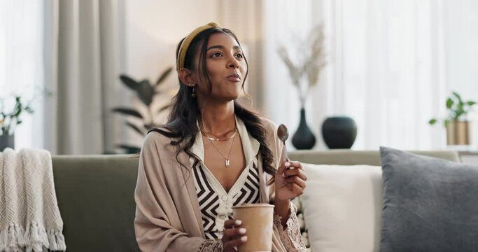Woman, eating ice cream and relax on sofa, thinking with memory and enjoy gelato at home. Chocolate, cold dessert and container in hands with frozen yogurt in living room and hungry with snack