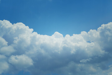 Cumulus clouds obscure half of the blue sky