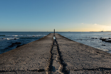 Empty concrete ocean jetty in afternoon sun in Cascais