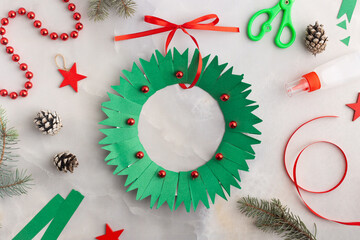 Christmas wreath from color paper with children. Step by step instructions. Handmade DIY new year holiday decoration project.
