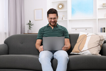 Happy man having video chat via laptop at home