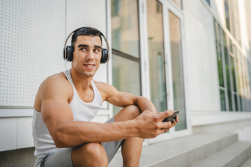 Portrait of man use headphones and smart phone to play video games