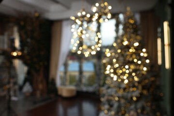 Fototapeta na wymiar Blurred view of stylish room interior with Christmas tree and festive decor