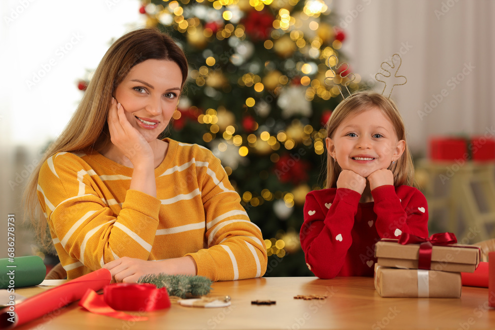 Canvas Prints Christmas presents wrapping. Happy mother and her little daughter at table with gift boxes in room