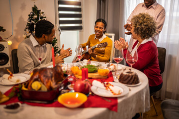 African American family playing guitar and singing  on Christmas Eve.