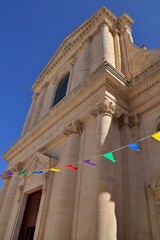  church building, columns, old building, Ionic columns, suspended colorful garlands, blue sky, Locorotondo, Italy