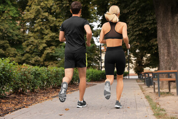 Healthy lifestyle. Couple running in park, back view