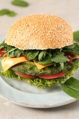 Tasty vegetarian burger with spinach cutlet, cheese and vegetables on white table, closeup