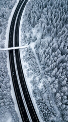 Landstraße mit Brücke durch verschneiten Wald im tiefsten Winter